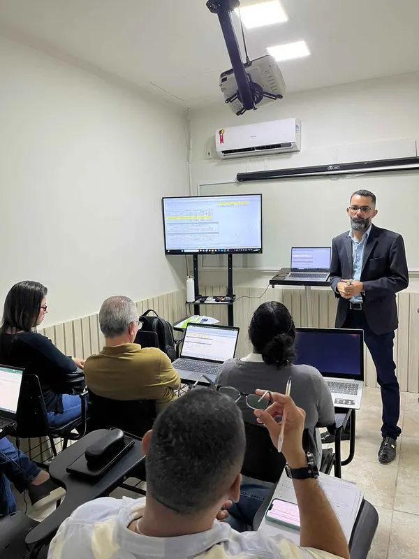 Participantes acompanhando treinamento com notebooks